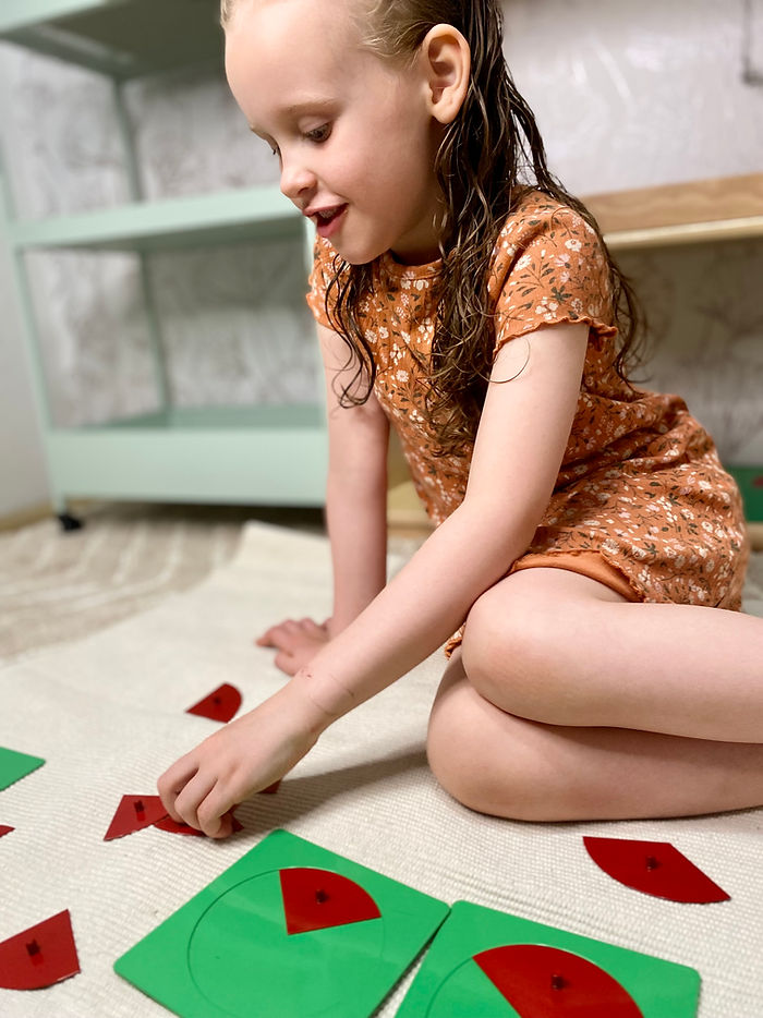 A child doing fractions with Montessori fraction insets